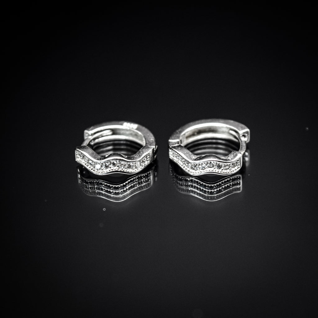 A pair of silver-colored hoop earrings with cubic zirconia,