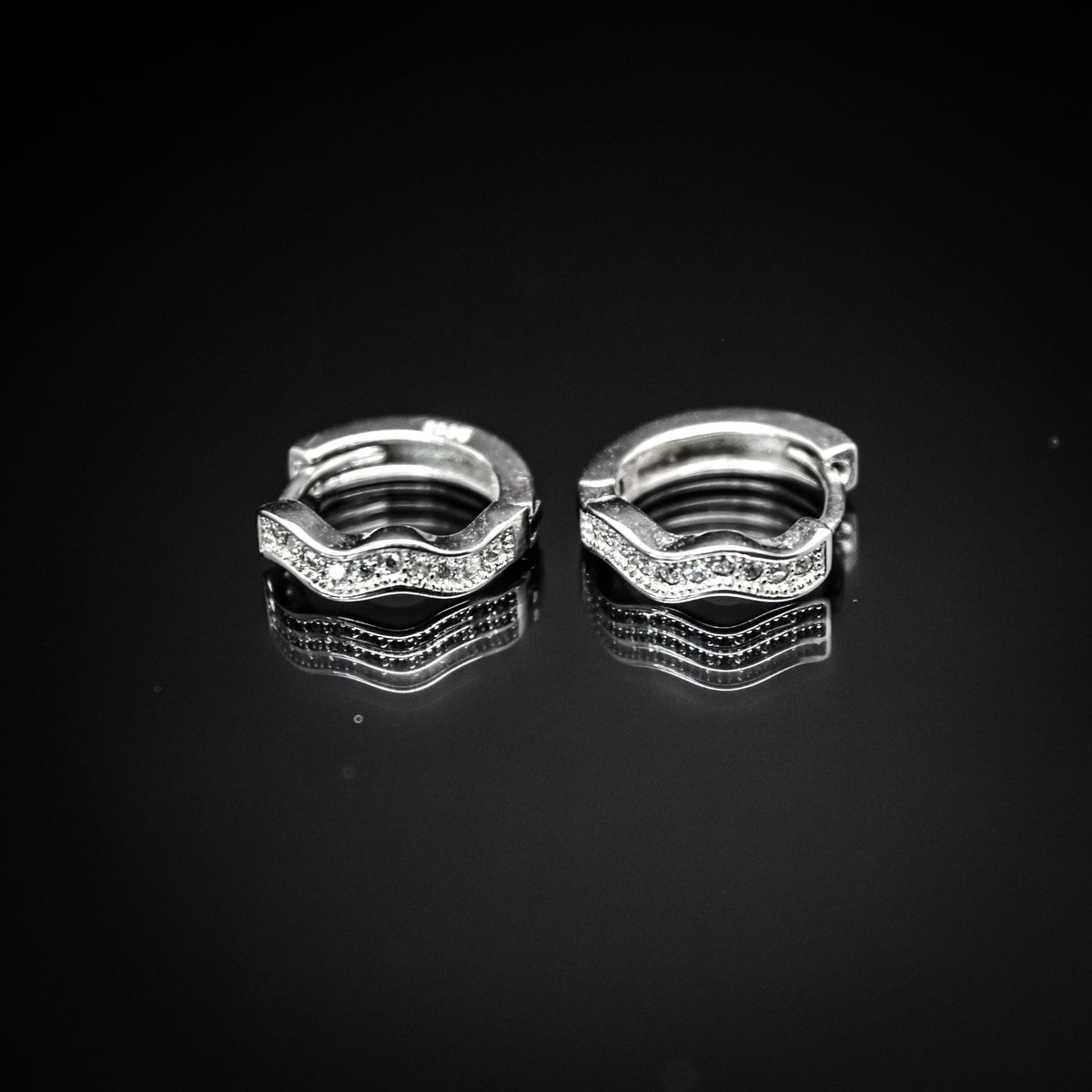A pair of silver-colored hoop earrings with cubic zirconia,
